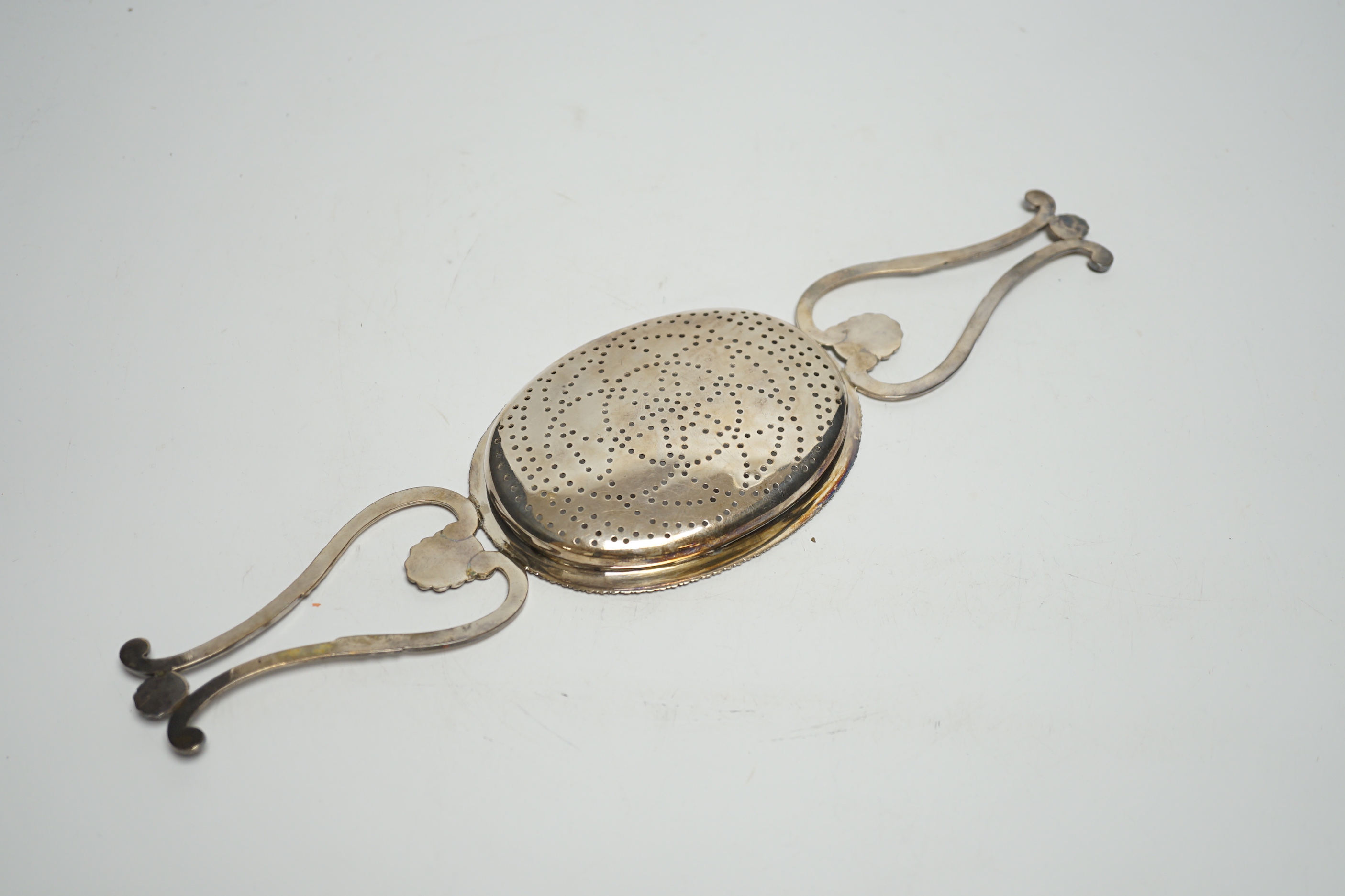 A George IV Scottish silver lemon strainer, Philip Grierson, Glasgow, 1821, 33.3cm, 167 grams